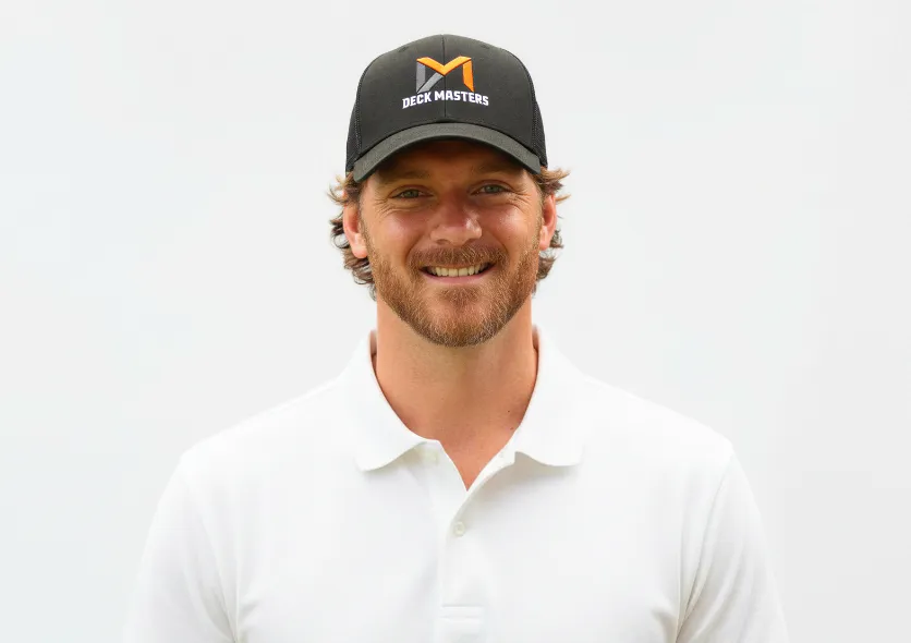Jordan Webb, owner of Deck Masters, smiling in a white shirt and hat.